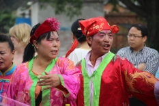 Grooms parents who are dressed like Chinese clowns